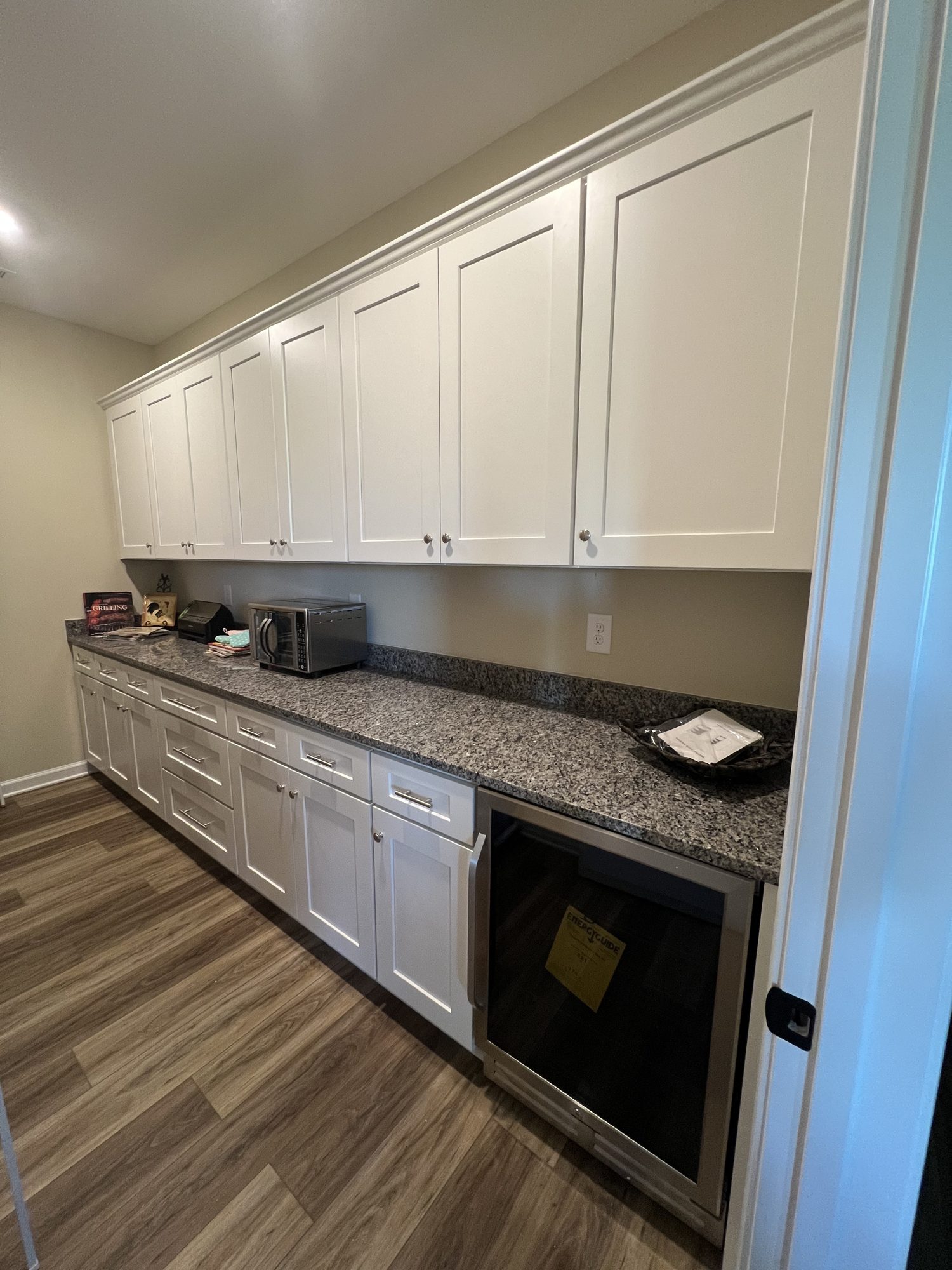 Galley kitchen with granite countertops and white cabinets